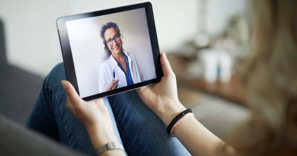 Female doctor on tablet for a telehealth visit