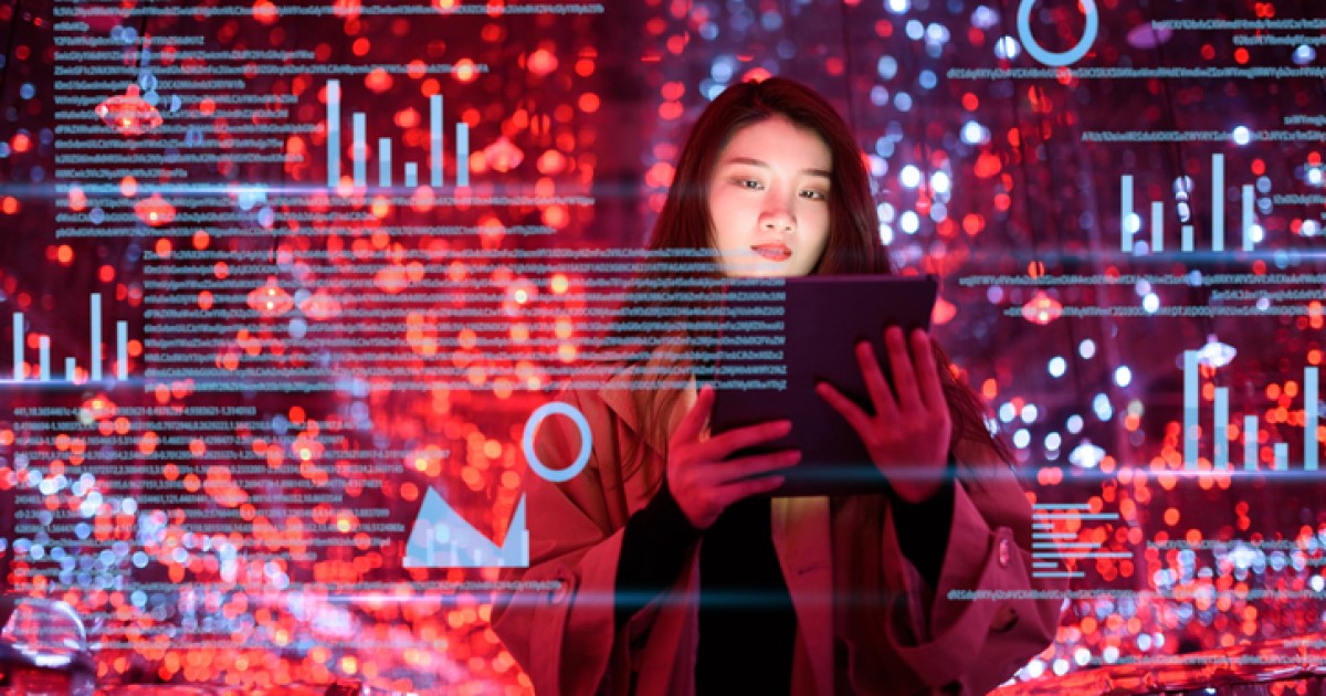 A person looks at a tablet, and red and blue pixelated data appears