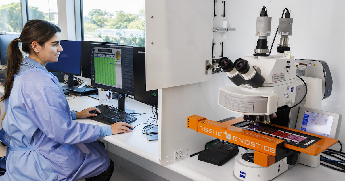 A scientist looks at images on a computer screen as slides are digitally scanned into the system.