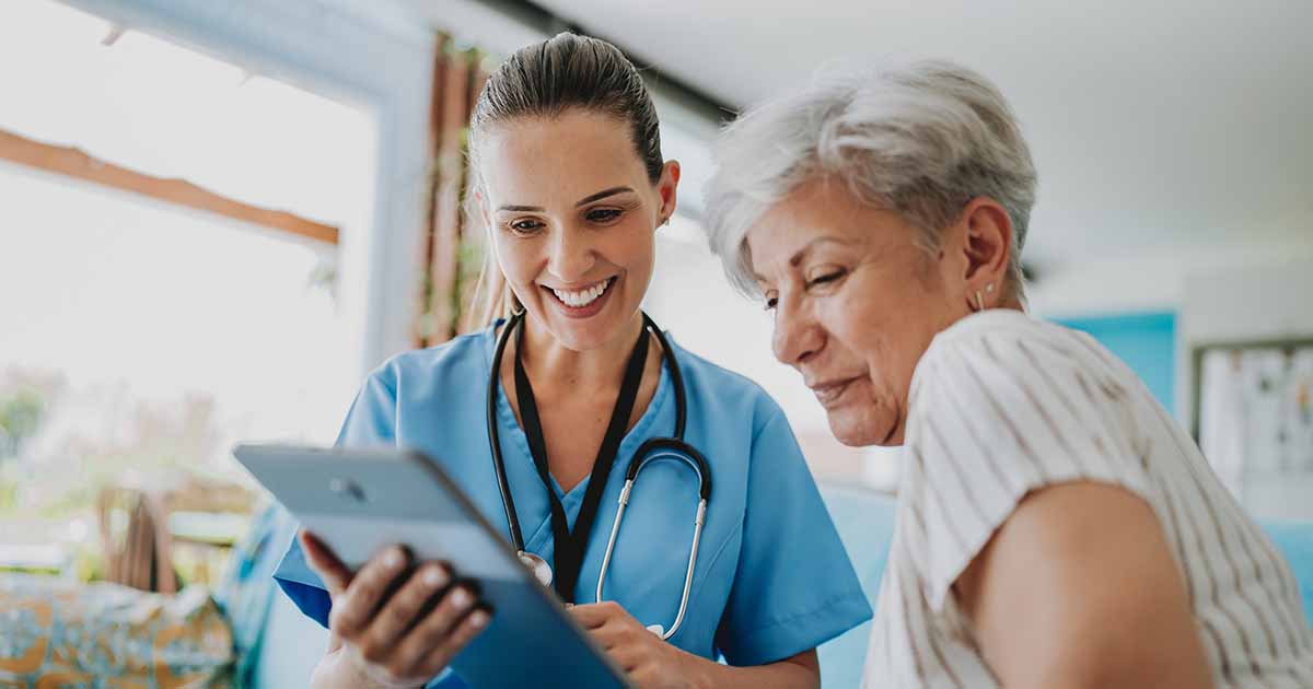 Healthcare worker showing tablet to patient
