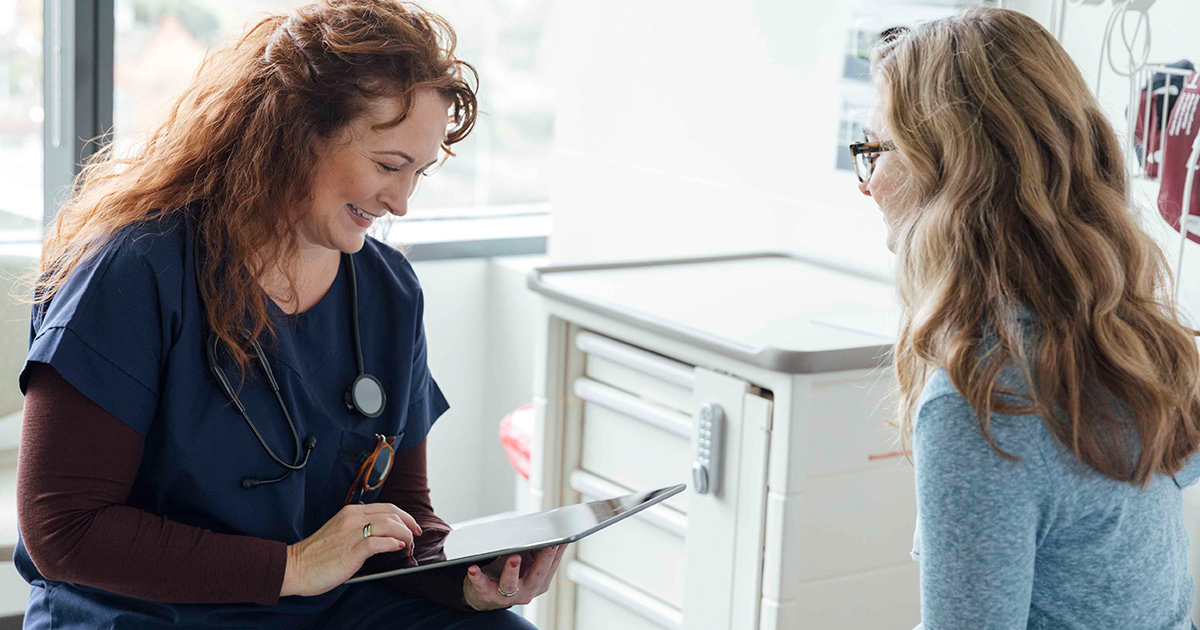 Doctor with tablet talking to patient