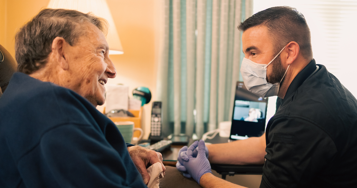 Masked healthcare worker talking to patient