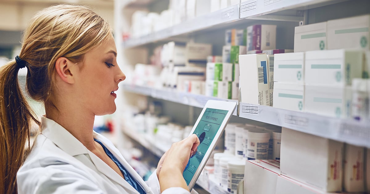 Pharmacist taking inventory with a tablet