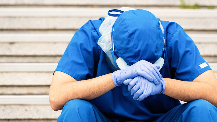 Medical worker with head in hands