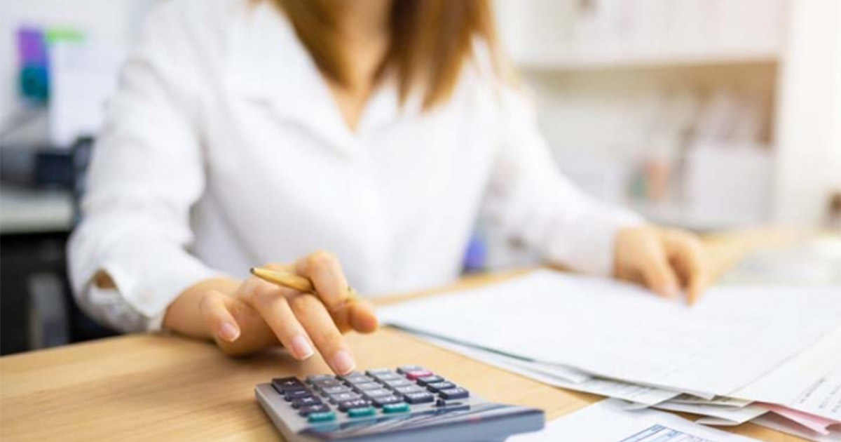 Woman at a desk works on a calculator