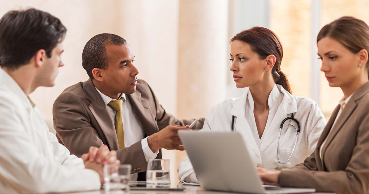 Doctors meeting with business people