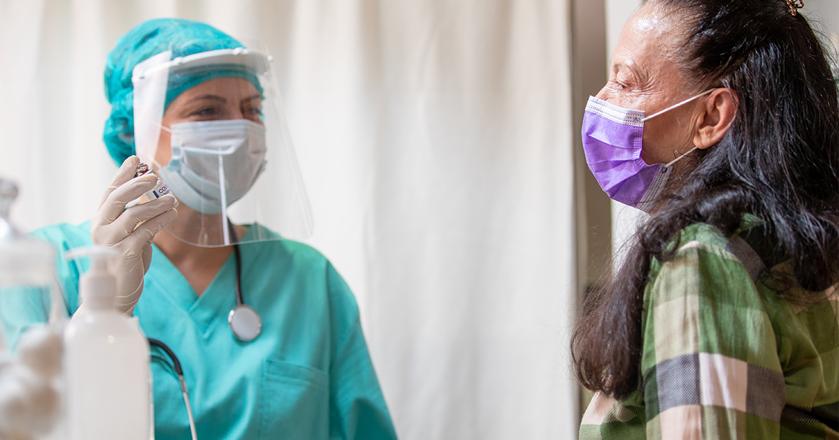 Doctor in PPE with patient in mask