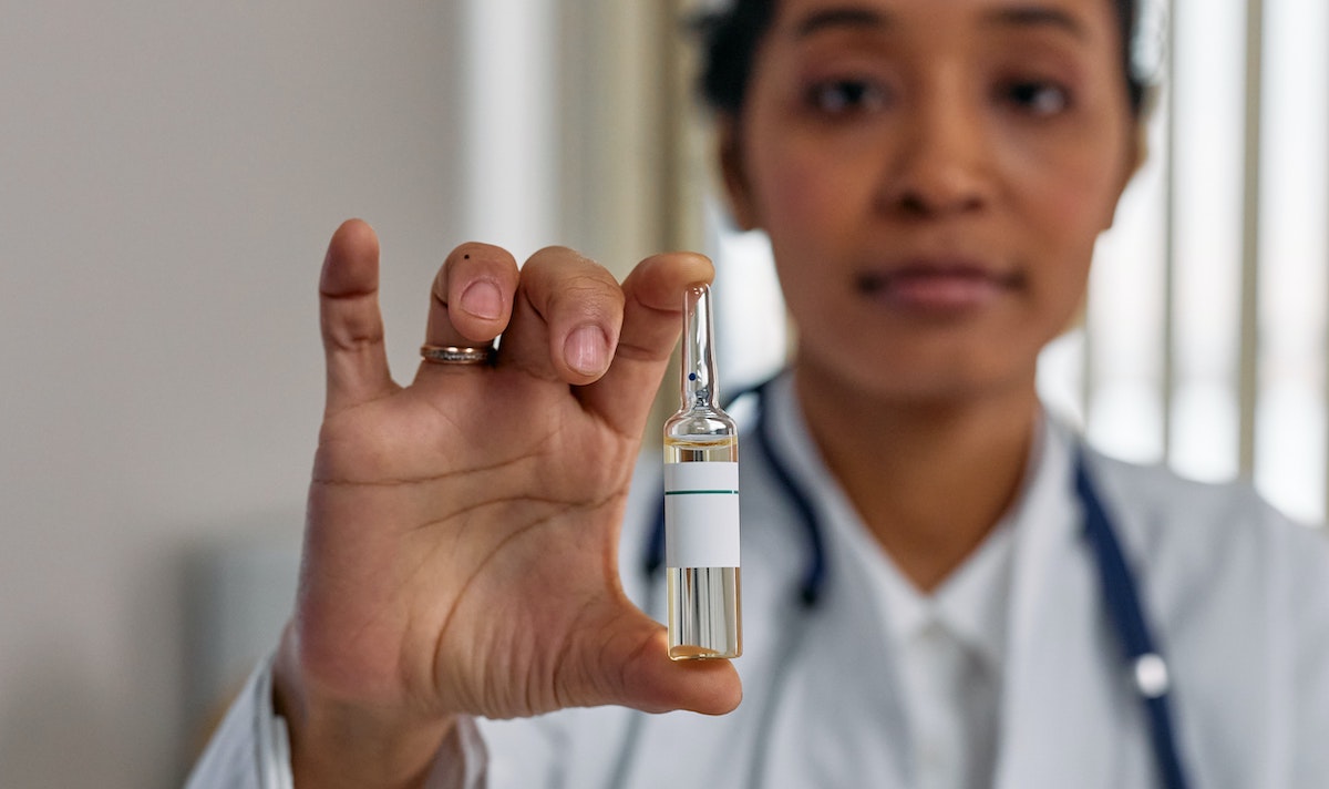 Medical worker holding glass vial