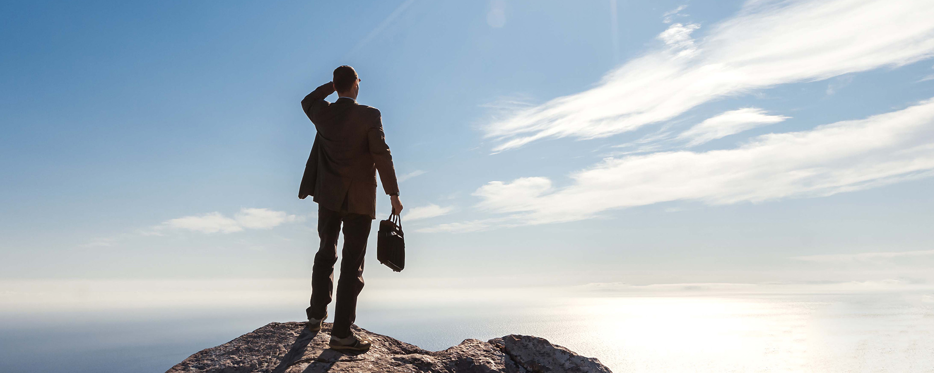Businessperson looking out from a mountaintop
