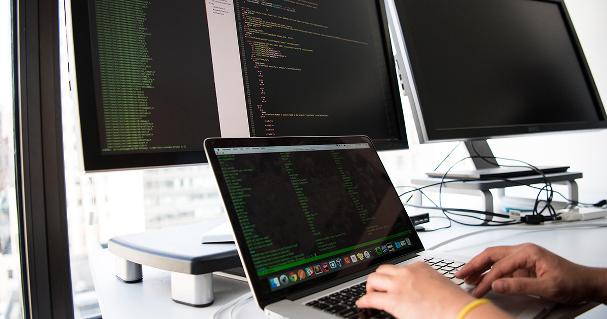 Developer typing on multiple screens