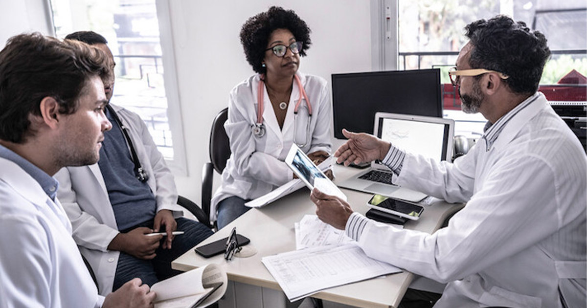 Doctors sitting at a desk and discussing data