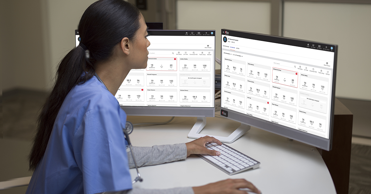Healthcare worker working on a computer with dual monitors