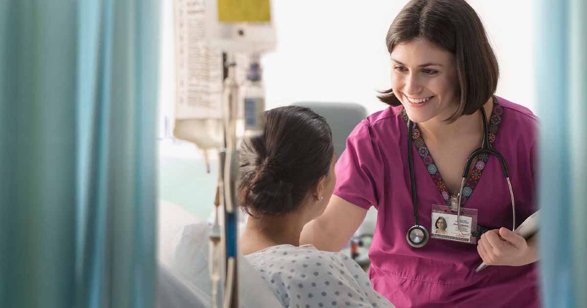 Healthcare worker talking to patient in hospital