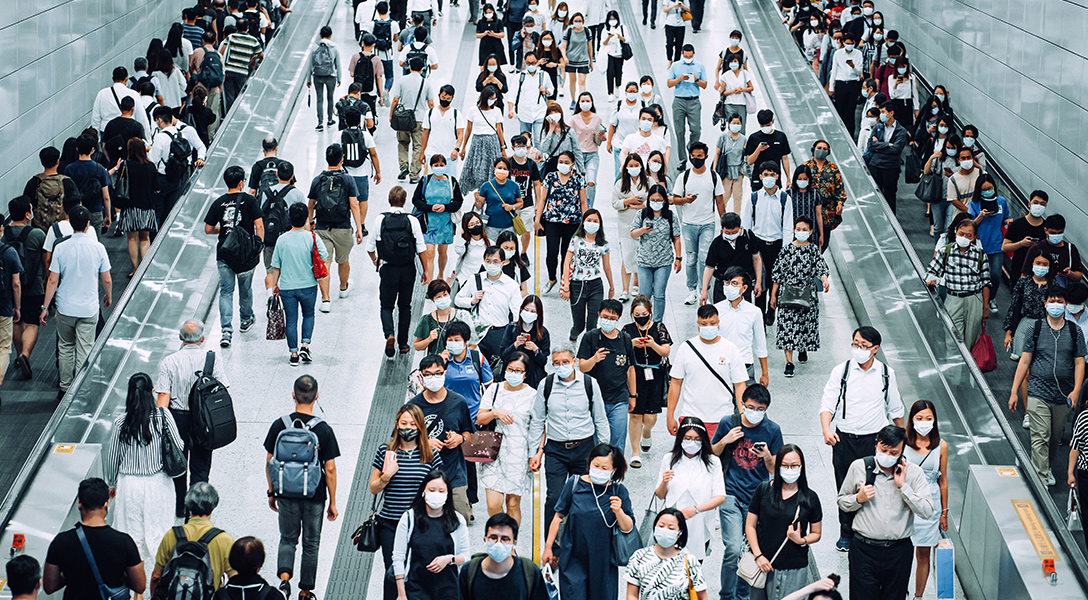 Crowd of commuters wearing masks