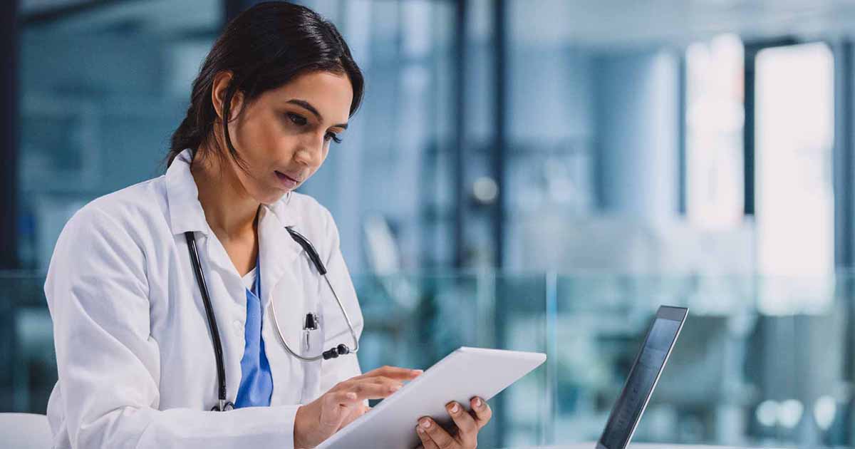 Doctor using tablet and laptop