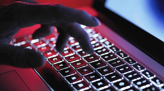 Cybersecurity - hacker's hand at keyboard