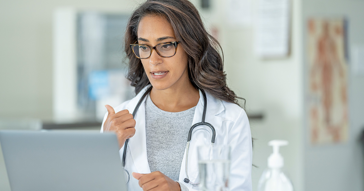 Doctor gesturing to laptop screen