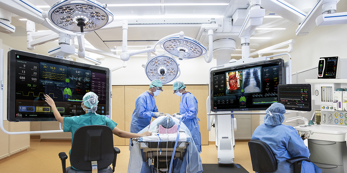 Surgery taking place with doctors working from digital monitors