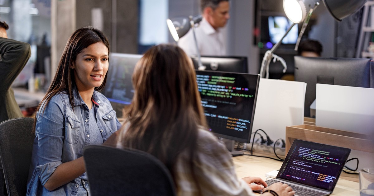 Coders with code on screen talking
