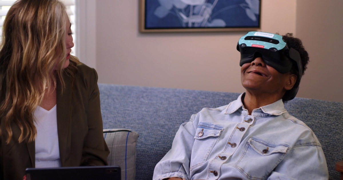 Person using VR headset while another looks on