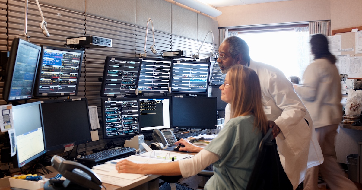 Healthcare workers looking at group of monitors