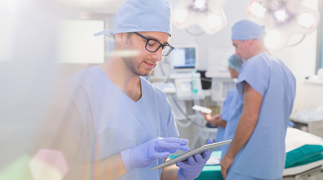 Medical worker in scrubs using a tablet