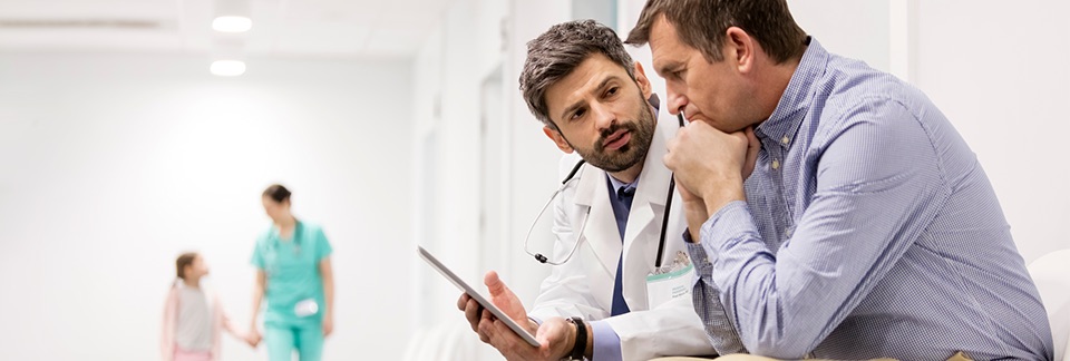 Doctor showing tablet to patient