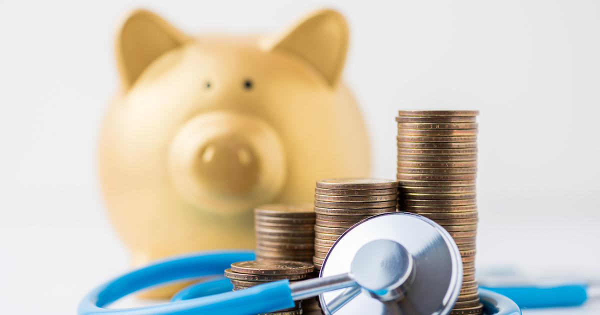 Piggy bank with stack of coins and stethoscope