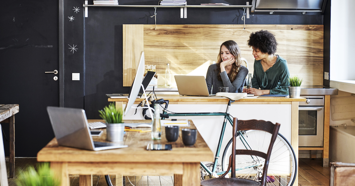 Two workers using laptop in modern office