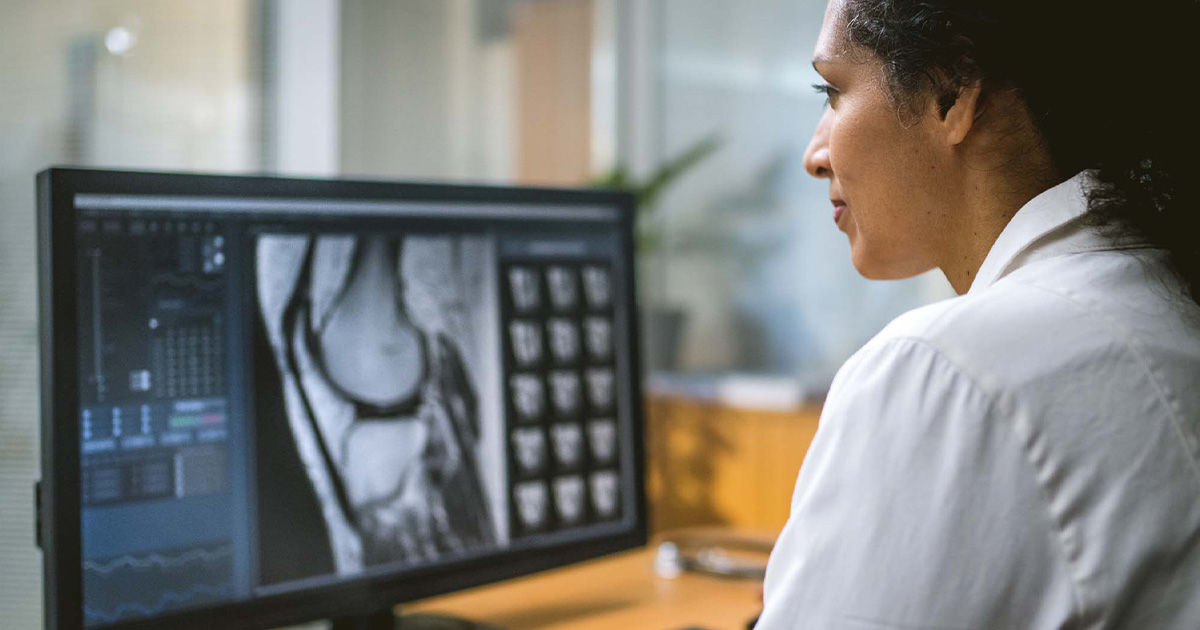 Healthcare worker looking at medical image on computer
