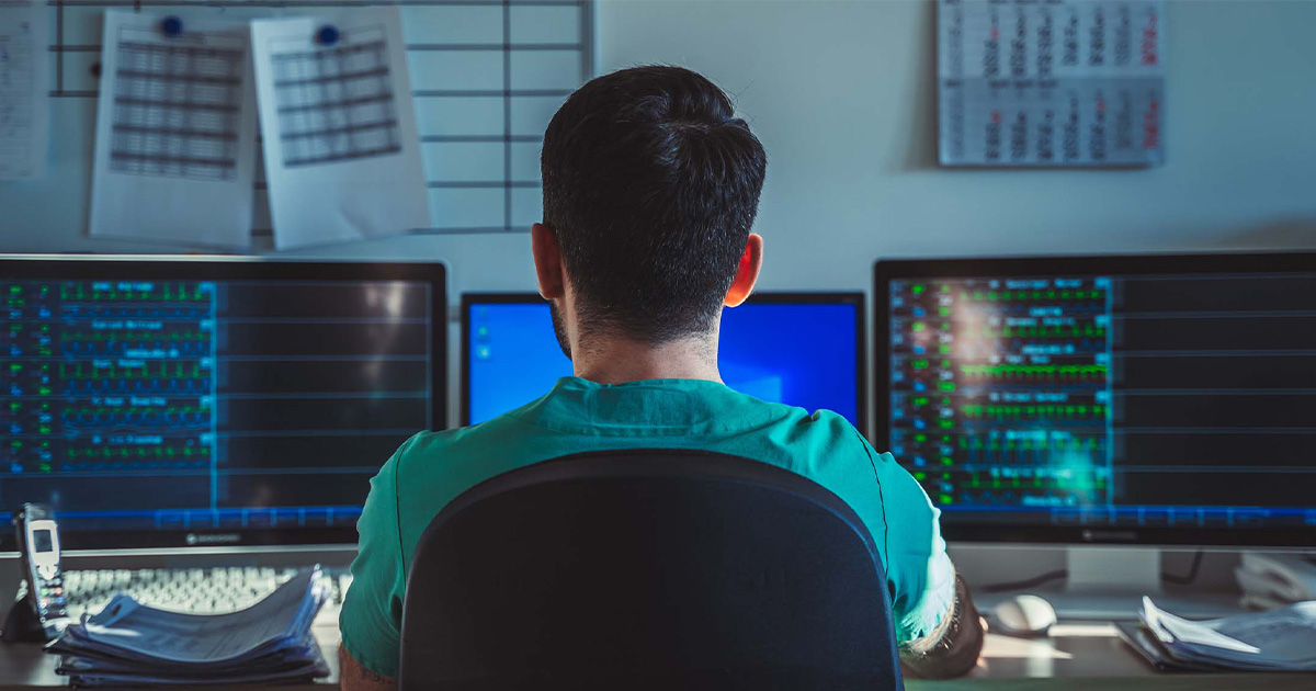 Healthcare worker looking at multiple monitors