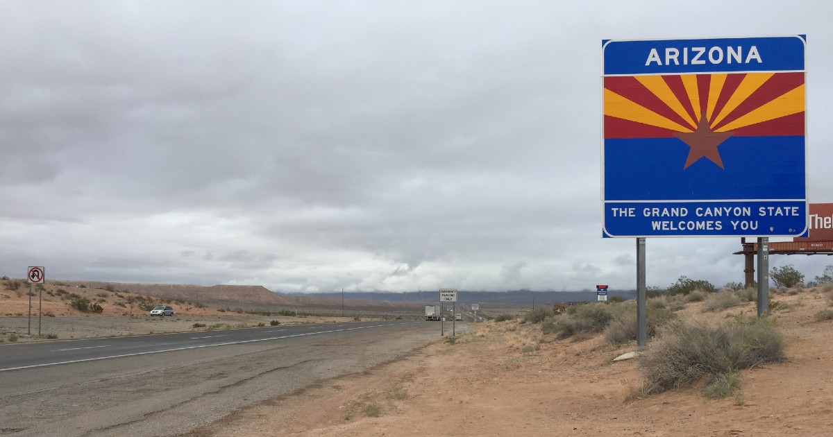 A highway sign with the words "Welcome to Arizona"