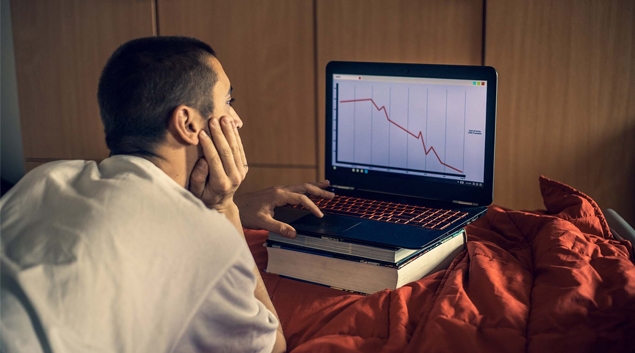 Person looking at declining line graph on a laptop