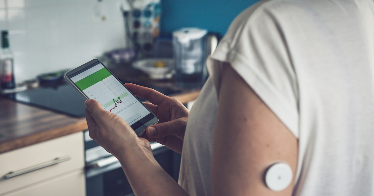 Patient checking glucose levels on a phone app