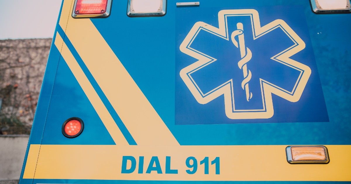 The back of an ambulance painted with a medical symbol and the words "Call 911"