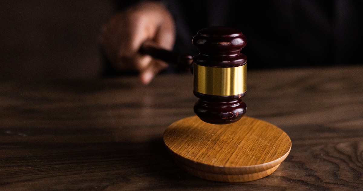Hand holding judge's gavel