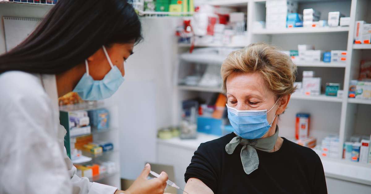 Person in mask recieving vaccine at a pharmacy