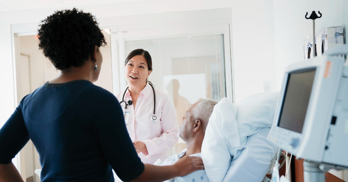 A patient and their family member speaking to a doctor in the hospital