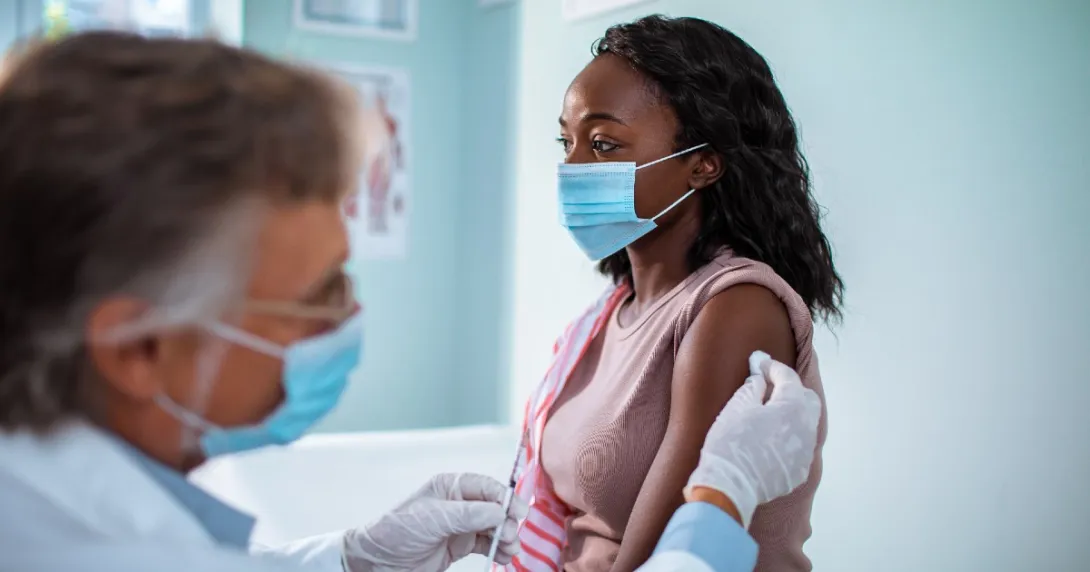 woman receives a shot from a male clinician