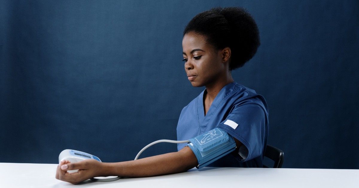 A clinician using a blood pressure monitor