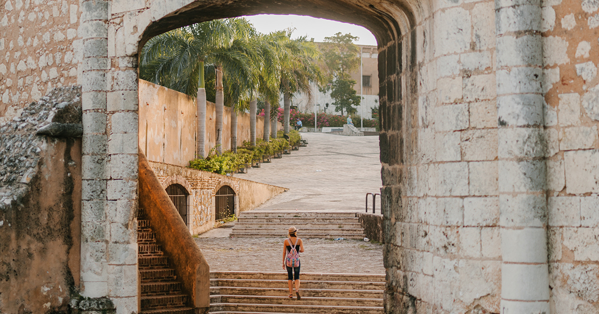 person standing in a city archway on stairs