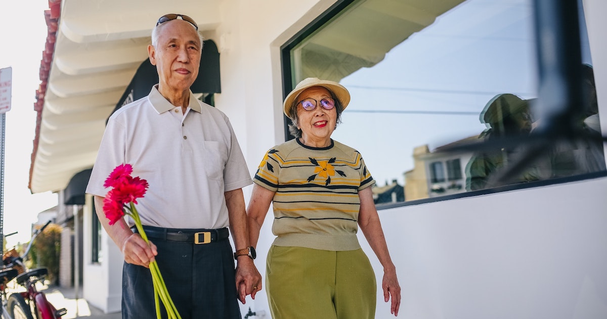 An elderly couple taking a walk while holding hands