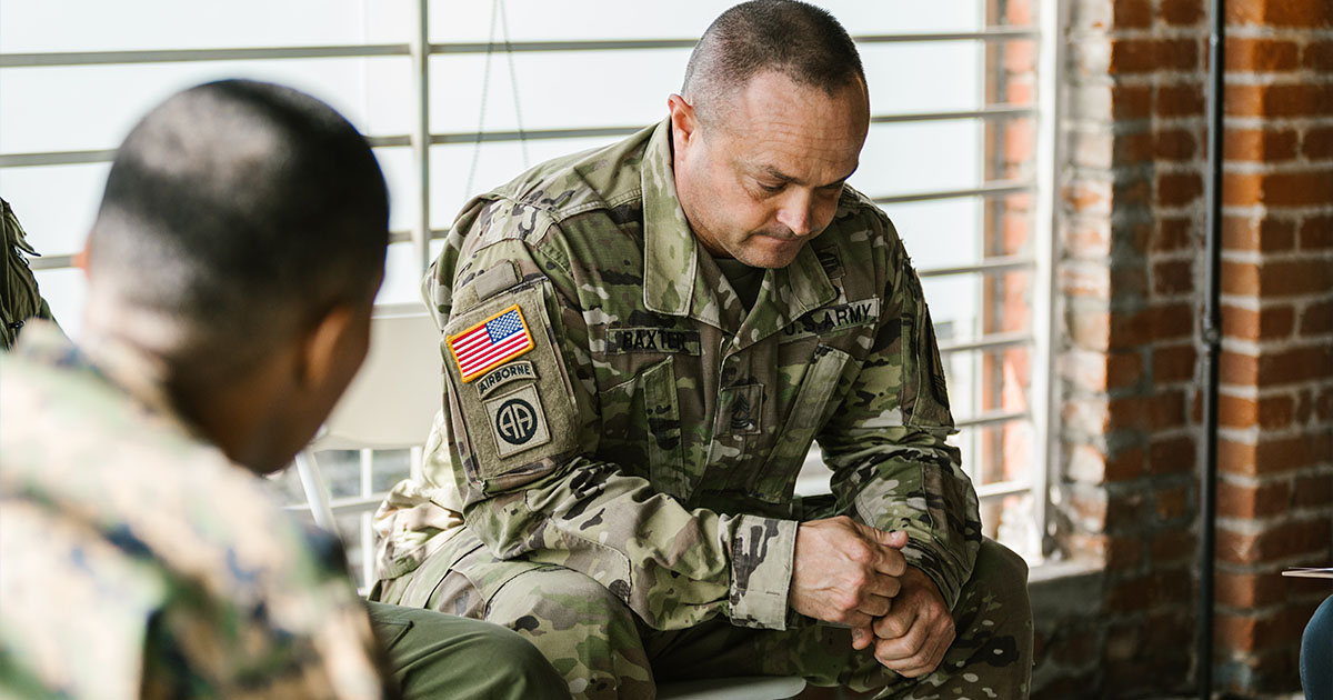 People in army uniforms seated in a discussion