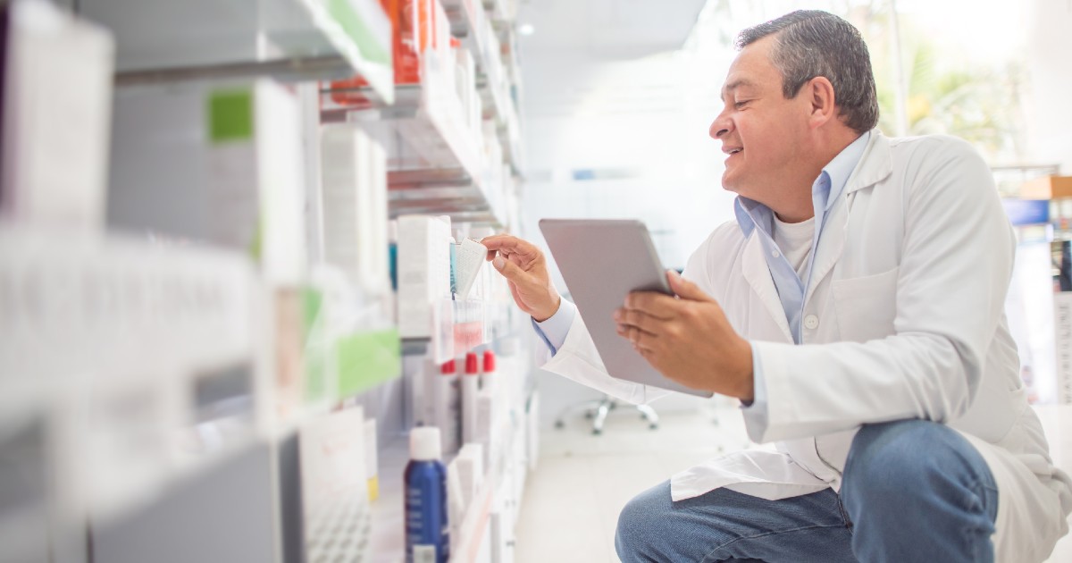 A pharmacist looks at a shelf of medications