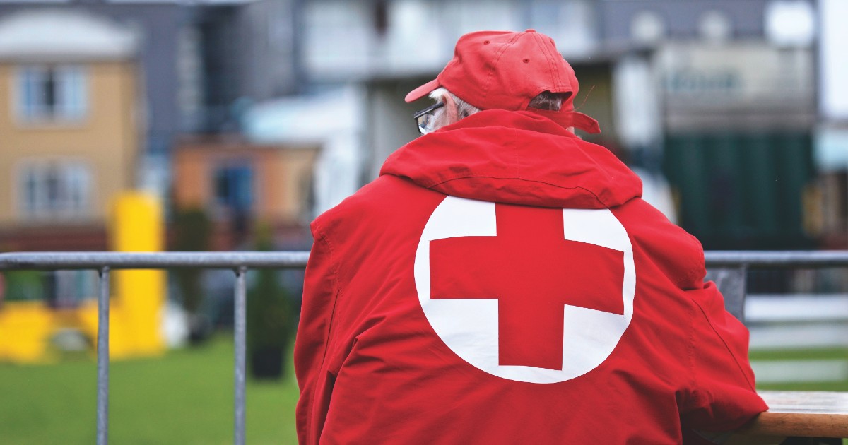 A man in a Red Cross jacket