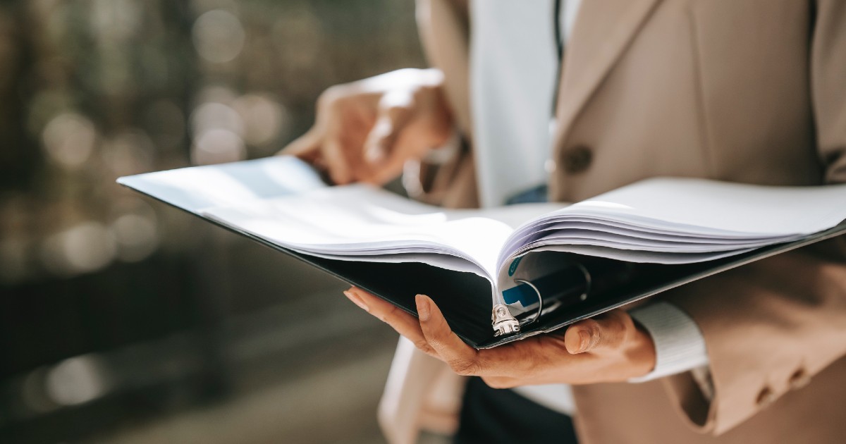 A person holding an open binder