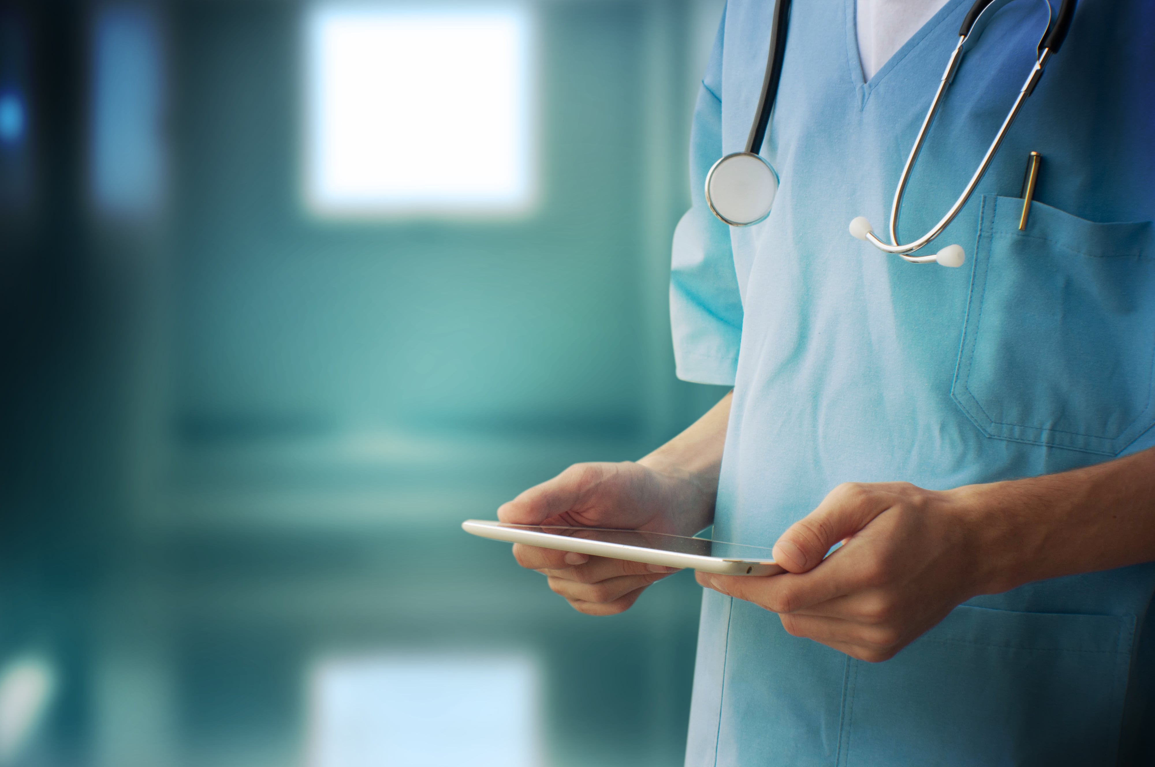 A medical staff holding a tablet.