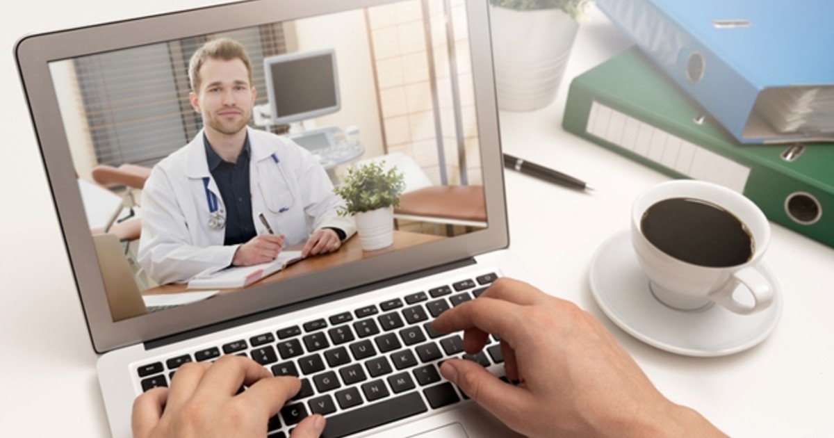 A doctor in a white coat on a computer screen