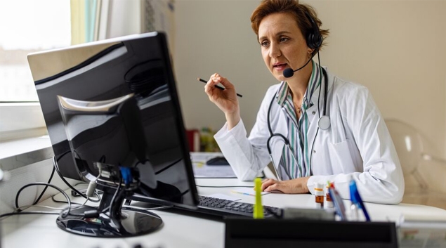 Doctor with headset talking to monitor