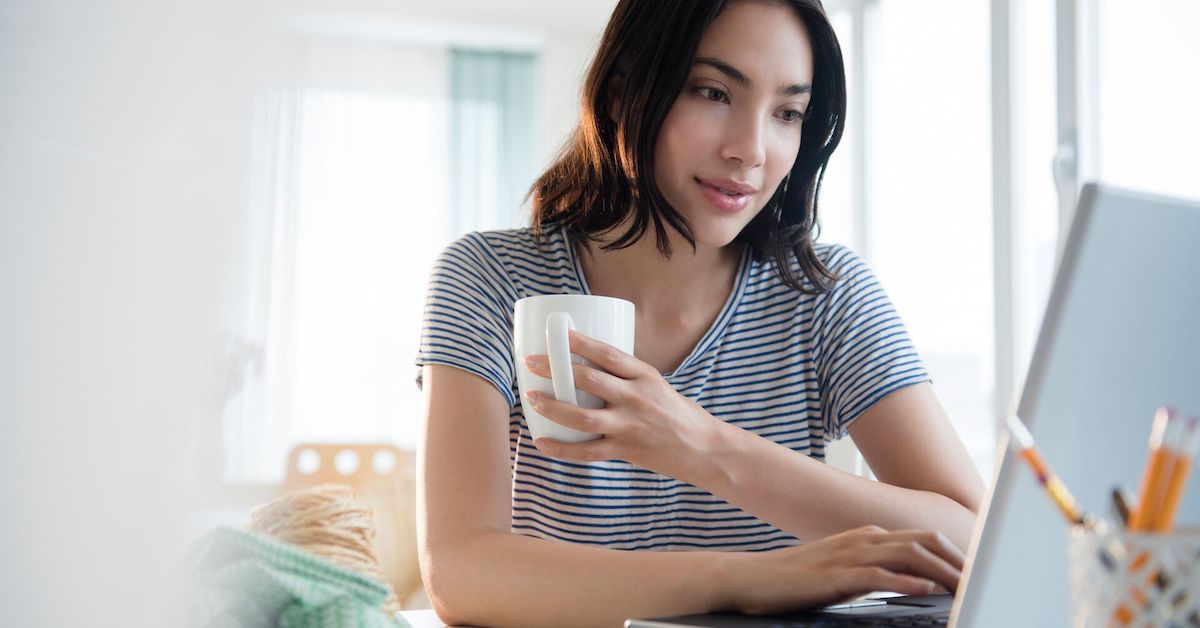 Person with coffee mug using computer